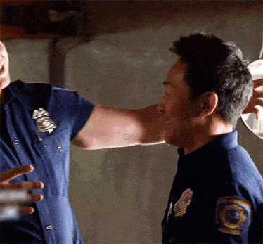 two police officers are having a conversation and one has a patch on his shoulder that says ' emergency services '