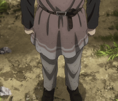 a person with a belt around their waist is standing on a dirt road