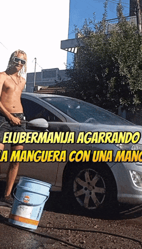 a shirtless man is washing a car with a gulf bucket in front of it