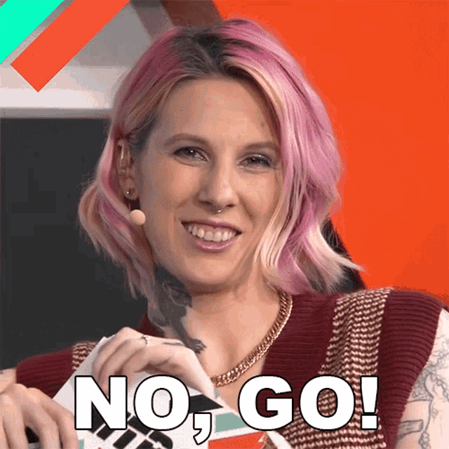 a woman with pink hair is smiling and holding a card that says no go