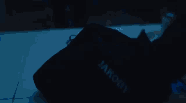 a person is swimming in a pool with blue lights