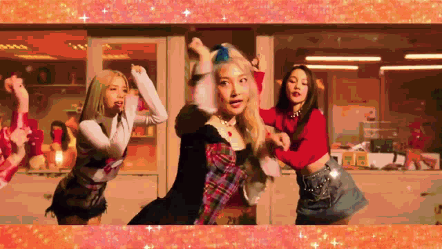 a group of young women are dancing in a room with a red background