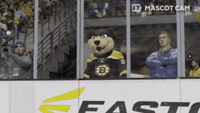 a mascot with the letter b on his jersey stands in front of a fast logo