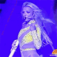 a woman is singing into a microphone on a stage .