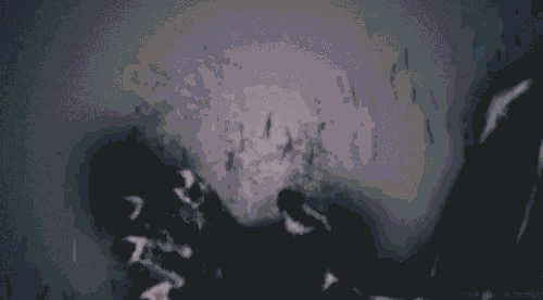 a close up of a person 's hands in a dark room with a blurred background .