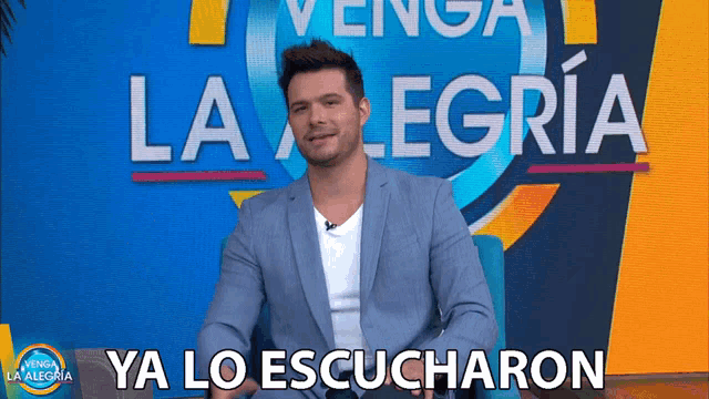 a man is sitting in front of a sign that says venga la alegria