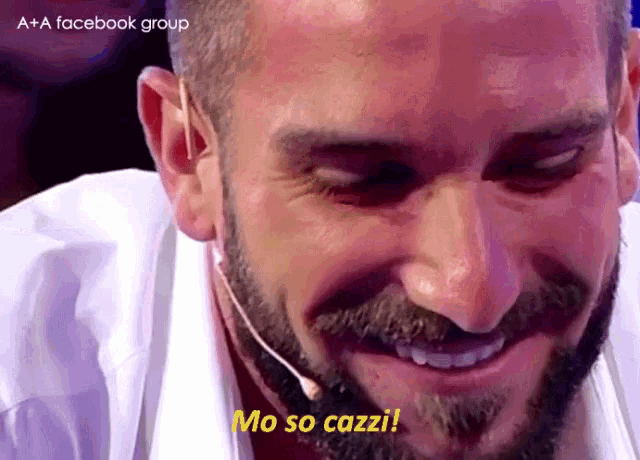 a man with a beard and a microphone says mo so cazzi