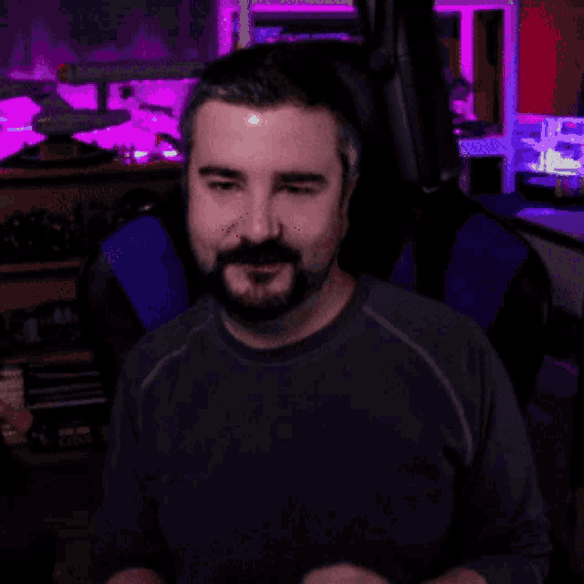 a man with a beard wearing headphones is smiling