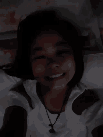 a young girl is smiling in the dark and wearing ear buds