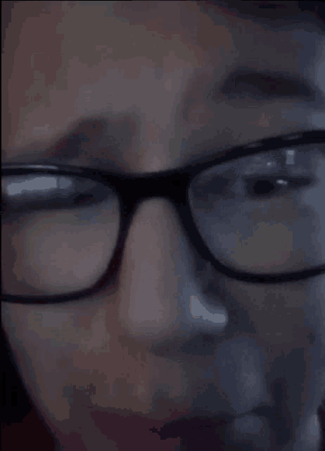 a close up of a person 's face with glasses