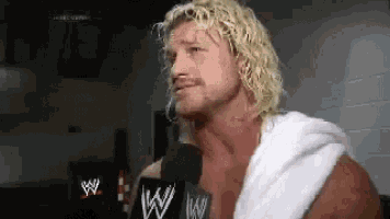 a man with blonde hair and a beard is wearing a white towel around his neck .