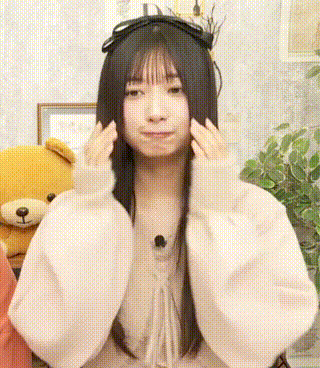 a girl with long black hair is wearing a white sweater .