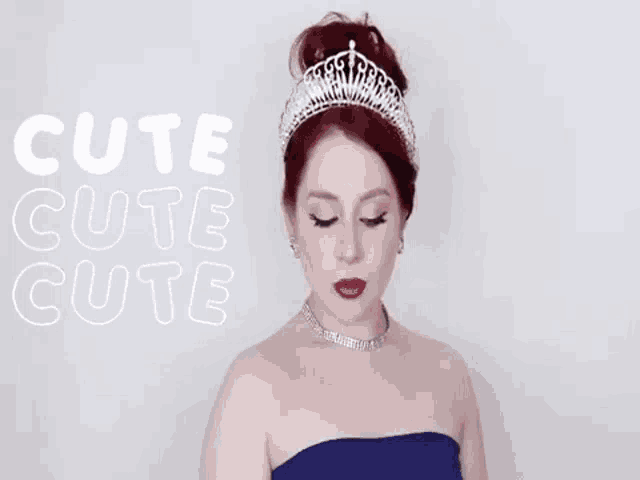 a woman wearing a tiara and a blue dress is looking at the camera .