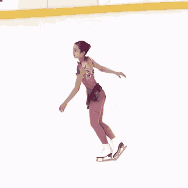 a woman in a pink leotard is skating on a rink