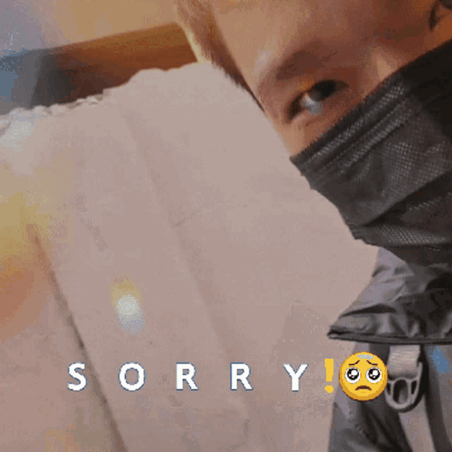 a man wearing a face mask with the word sorry written below him