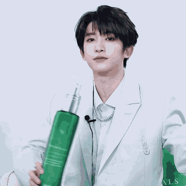 a man in a white jacket is holding a green bottle with the word als on it