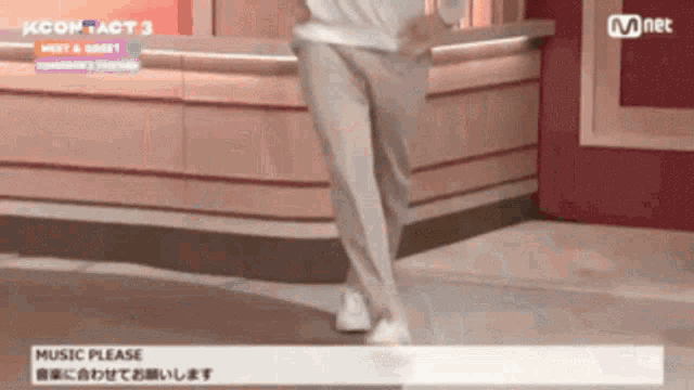 a person is dancing in front of a mnet banner