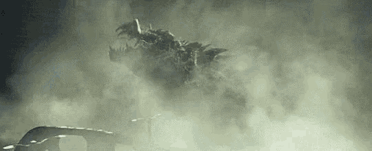 a monster is flying through the air above a car in a foggy area .