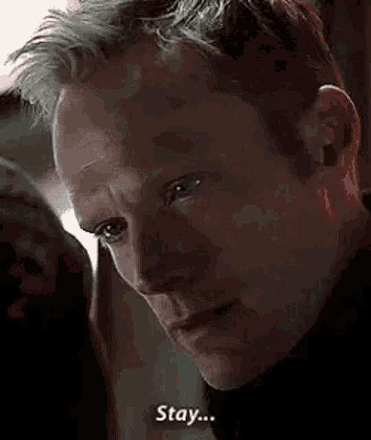 a close up of a man 's face with the words `` stay '' written below him .