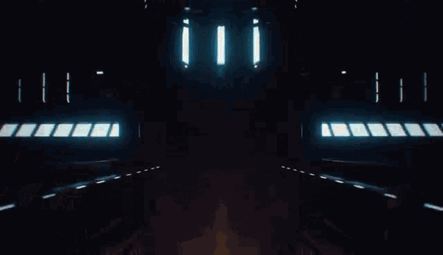 a person is walking through a dark room with a lot of lights