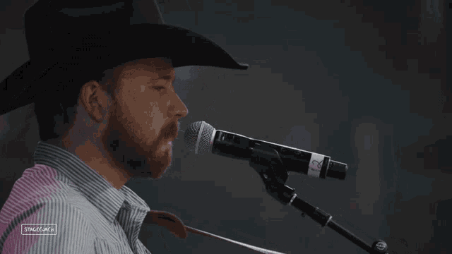 a man in a cowboy hat singing into a microphone with stagecam written on the bottom