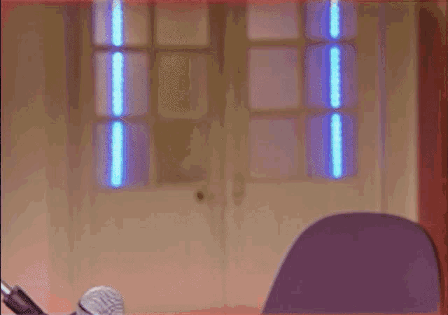 a person is standing in front of a microphone in a room