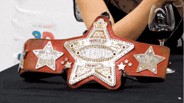 a woman holding a world of stardust championship belt