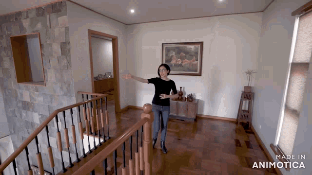 a woman in a black shirt is standing on a wooden staircase with the words made in animatica below her