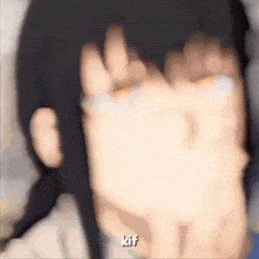 a blurry picture of a person covering their face with their hands with the word kif written on the bottom .