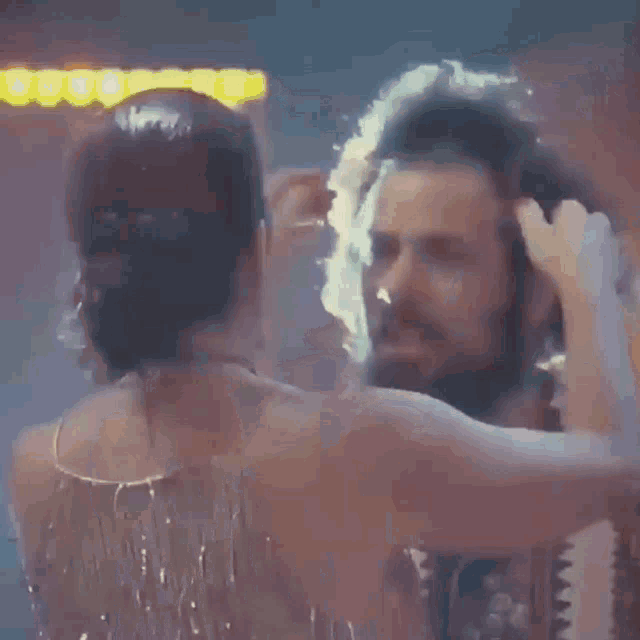 a woman in a dress is standing next to a man in a headband .