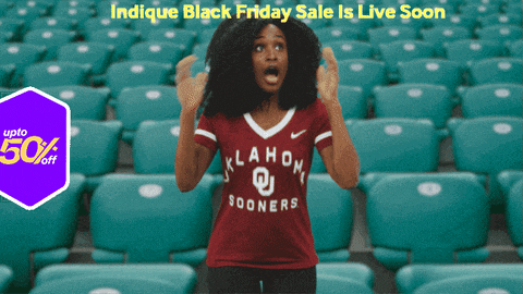 a woman wearing an oklahoma sooners shirt stands in front of a row of empty seats