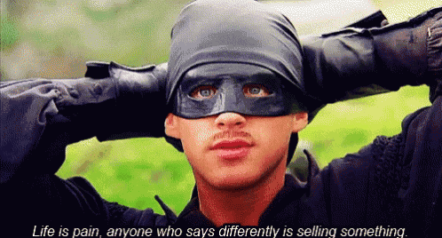 a man wearing a mask with the words life is pain anyone who says differently is selling something on the bottom