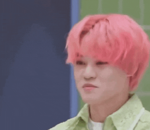 a close up of a person 's face with pink hair .