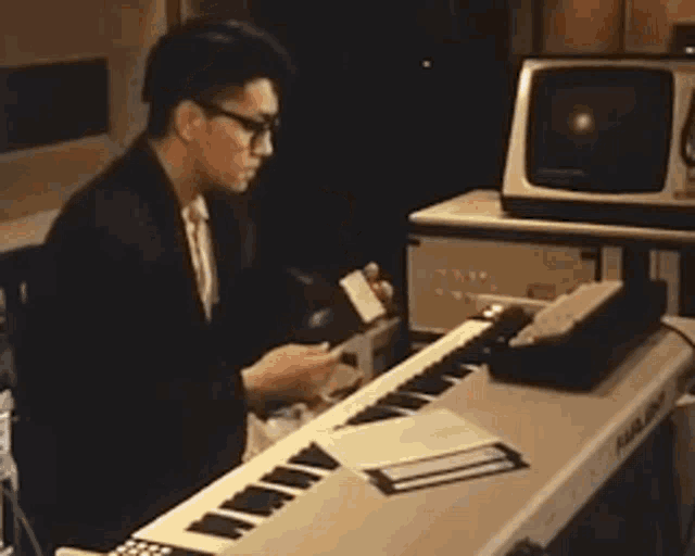 a man sitting at a keyboard with the words this is a system disc