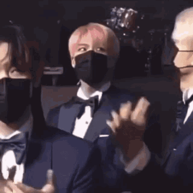 a group of men wearing face masks are standing next to each other .