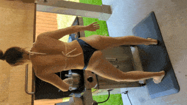 a woman in a bikini is standing on a black mat