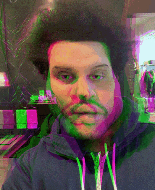 a man wearing a blue hoodie has a green and purple colored face