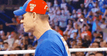 a man wearing a blue shirt and a red hat that says never give up