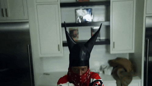 a person wearing a black helmet with horns and a red bandana