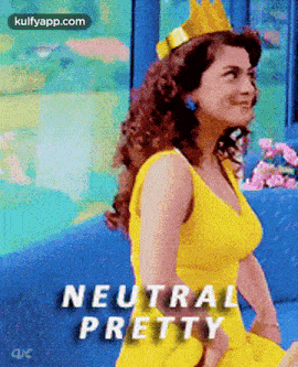 a woman in a yellow dress with a crown on her head is sitting on a blue couch .