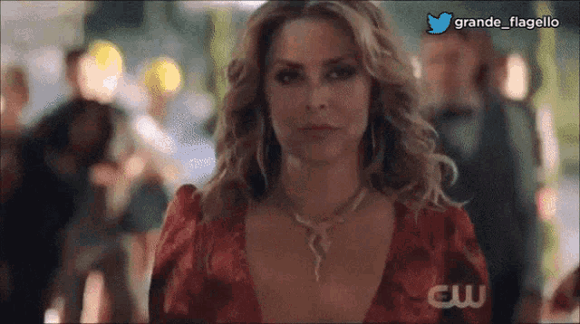 a woman in a red dress is standing in front of a crowd with the words grande flagello on the bottom