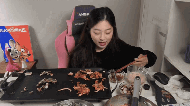 a woman sits at a table with a pink and black chair that says amber on it