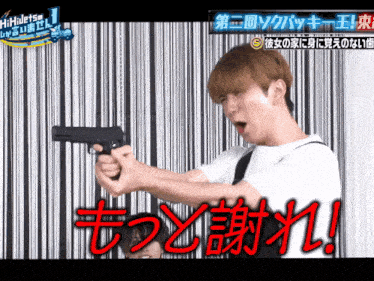 a man is holding a gun in front of a black and white wall