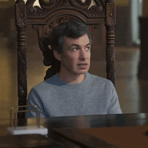 a man is sitting in a chair with uhh sure written on the table