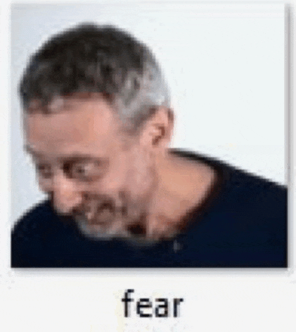 a man with gray hair and a beard is looking down with the word fear written below him .