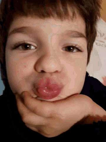 a child with a pacifier in his mouth looks at the camera