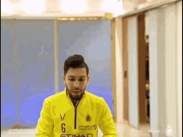a man wearing a yellow jacket with the number 6 on the front