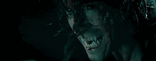a close up of a man with blood on his face and teeth