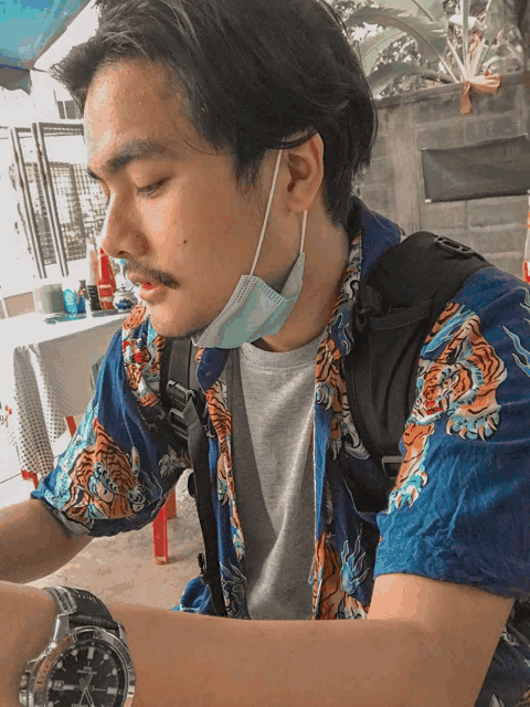 a man wearing a blue shirt with a tiger on it