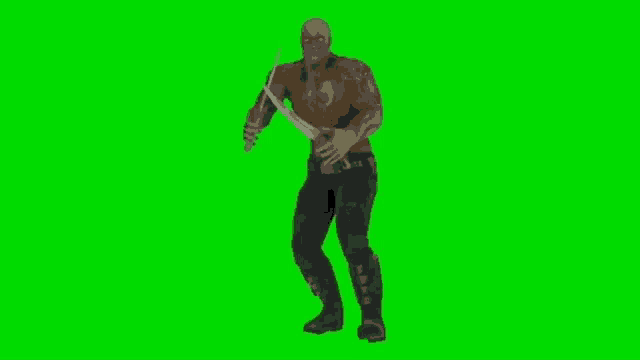 a man is holding a sword on a green screen and dancing .